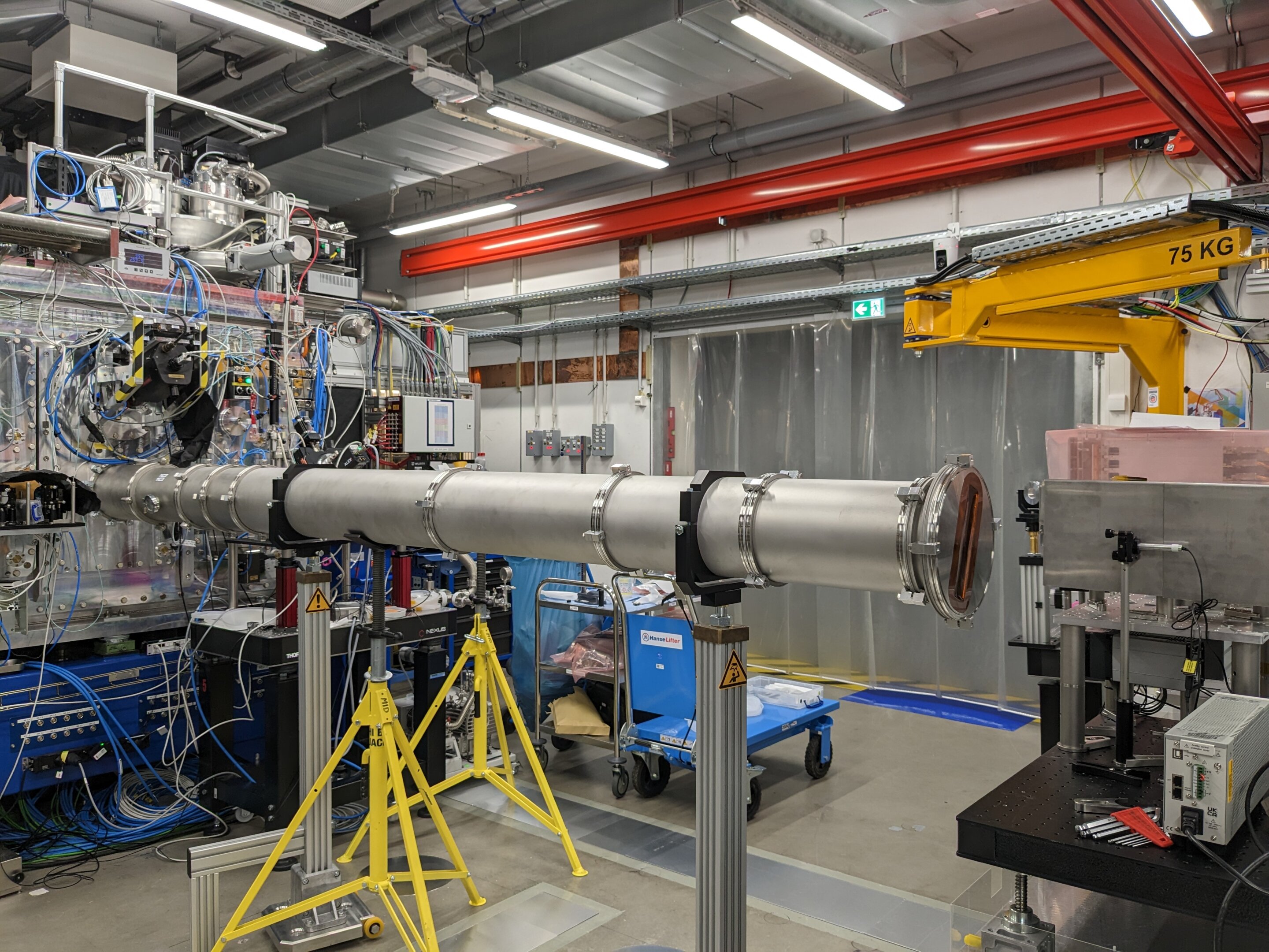 Experimental hall showing the target interaction chamber (left), the collection vacuum tube and the detector (right)